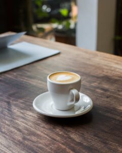 A serene moment with a cappuccino on a wooden table, featuring latte art in a cozy café setting.